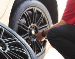 An America's Tire employee performing a rotation on a tire.