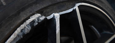 A close up image of a bent rim on a tire.
