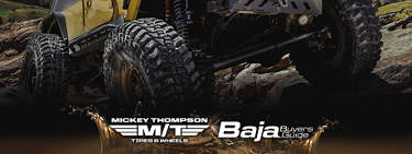 4x4 vehicle with Mickey Thompson tires crawling over rocks and mud