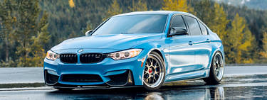 An image of a blue BMW vehicle with aftermarket BMW wheels on it.