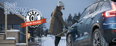 An image of a woman plugging in her electric vehicle in the snow with the words 'Best Snow Tires: Our Picks' to the top left.