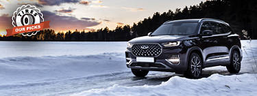 An image of a vehicle driving through snow during a sunset with the 'Tires: Our Picks' logo on the left.