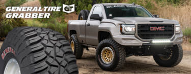 GMC pickup truck with General Grabber tires parked on a dirt road