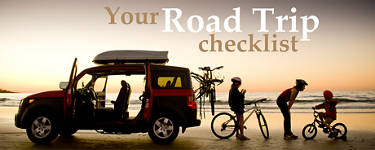 Silhouette of a family and their car on a beach