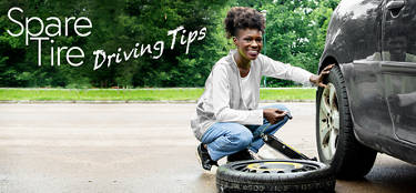 woman chaning a flat and installing a spare tire on her car