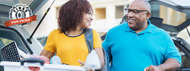 An image of a father and his daughter unloading a vehicle with stuff for college with the 'Tires: Our Picks' logo to the left. 
