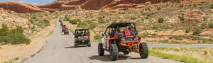 Line of ATVs driving on an unpaved desert road