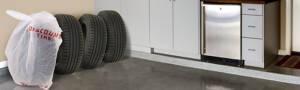 4 tires in a row with a discount tire bag on the end in a garage