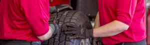 A winter tire with studs in the tread vs a tire with chains in the snow