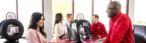 Customers talking with discount tire sales representatives in a showroom