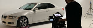 white car in front of a video camera and cameraman