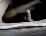 bent and damaged rim of a wheel near the edge of a tire