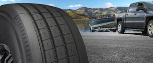 A trailer tire is featured on the left side of the image with a truck pulling a boat out of the water in the middle.