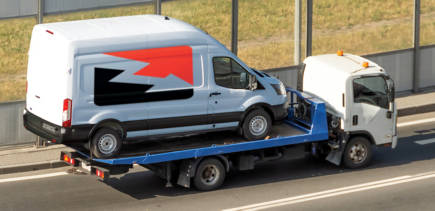 fleet van being towed on a flatbed