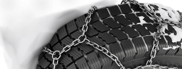 tire-chains on a tire with snow surrounding
