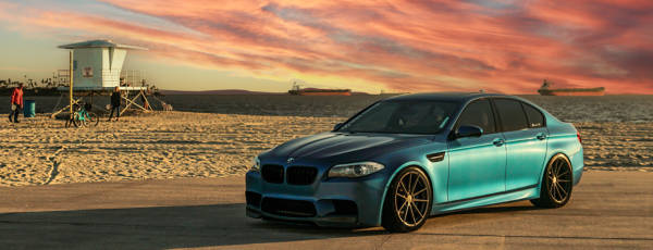 Green BMW sedan featuring passenger tires