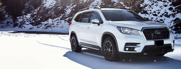 White crossover vehicle on a snowy street featuring winter tires