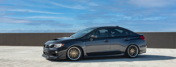 Black sport sedan featuring aftermarket machined wheels