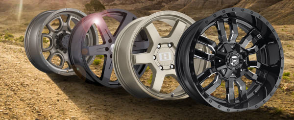 Assortment of 6x4 5 wheels against a background of dirt and a grass field.