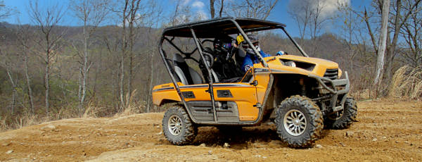 Yellow side by side with 12 inch tires in a field