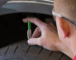 Technician inspecting a tire's tread depth