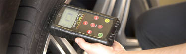 an image of a hand holding a TPMS tool up to a tire