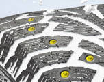 close up of winter tire tread with studs, impacted with snow