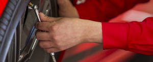 Technician checking air pressure of a tire