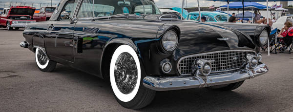 Classic car with whitewall tires parked on side of road.