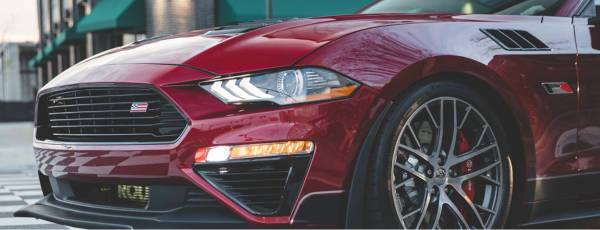 Close up of a maroon coupe featuring Continental tires