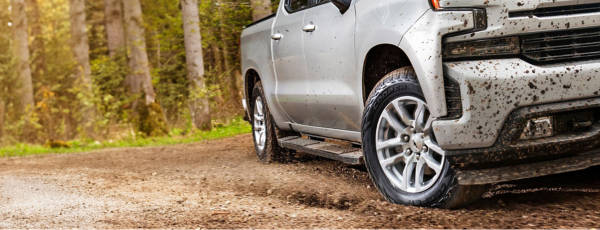 Vehicle driving on muddy path with Cooper Tires