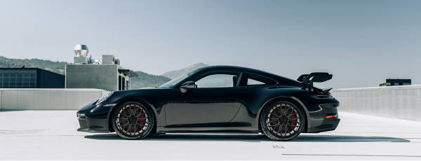 Porsche with Dolce Performance wheels parked on the street.