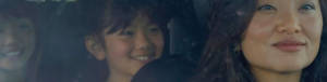 A happy mom confidently driving two children in a vehicle