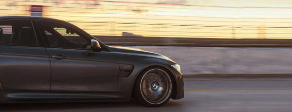 Goodyear Assurance tires on a BMW cruising across a city bridge