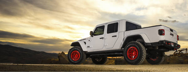 Jeep Gladiator with red wheels in the wilderness.