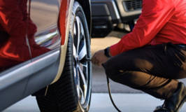 Tire technician adding air to a tire