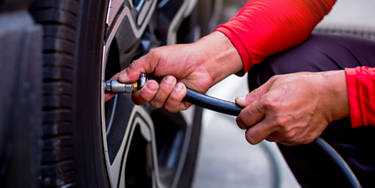An image of an employee putting air in tires.